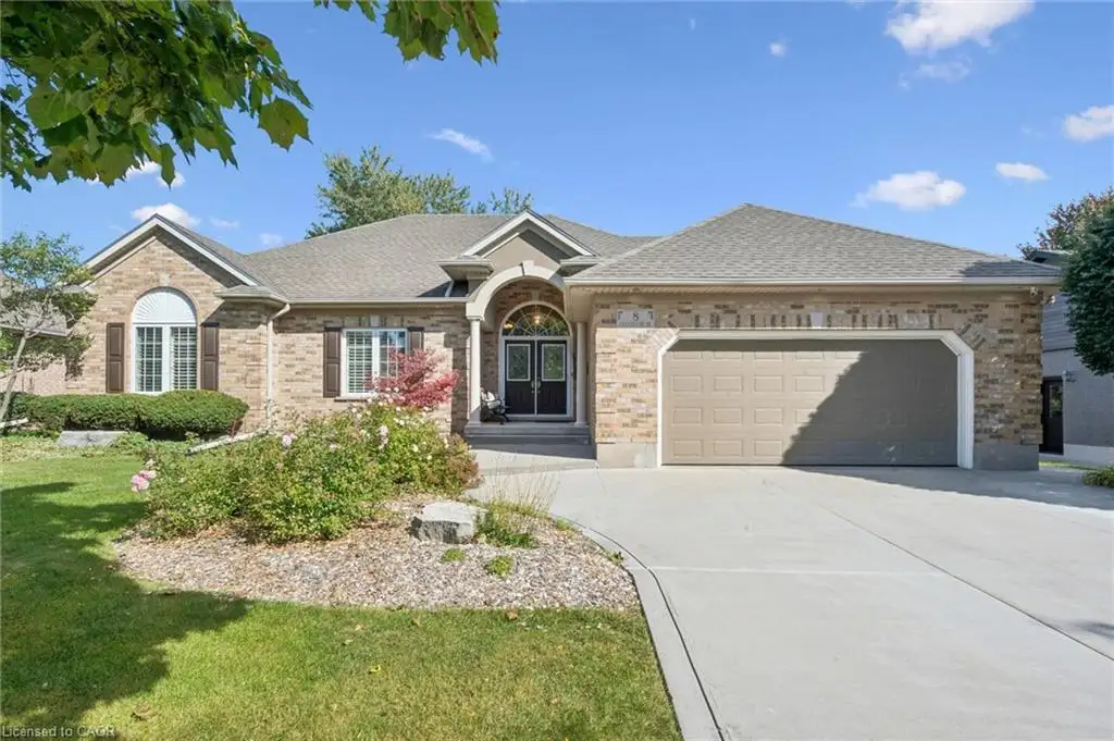 Brick exterior with an arched entryway, double front doors, and a concrete driveway