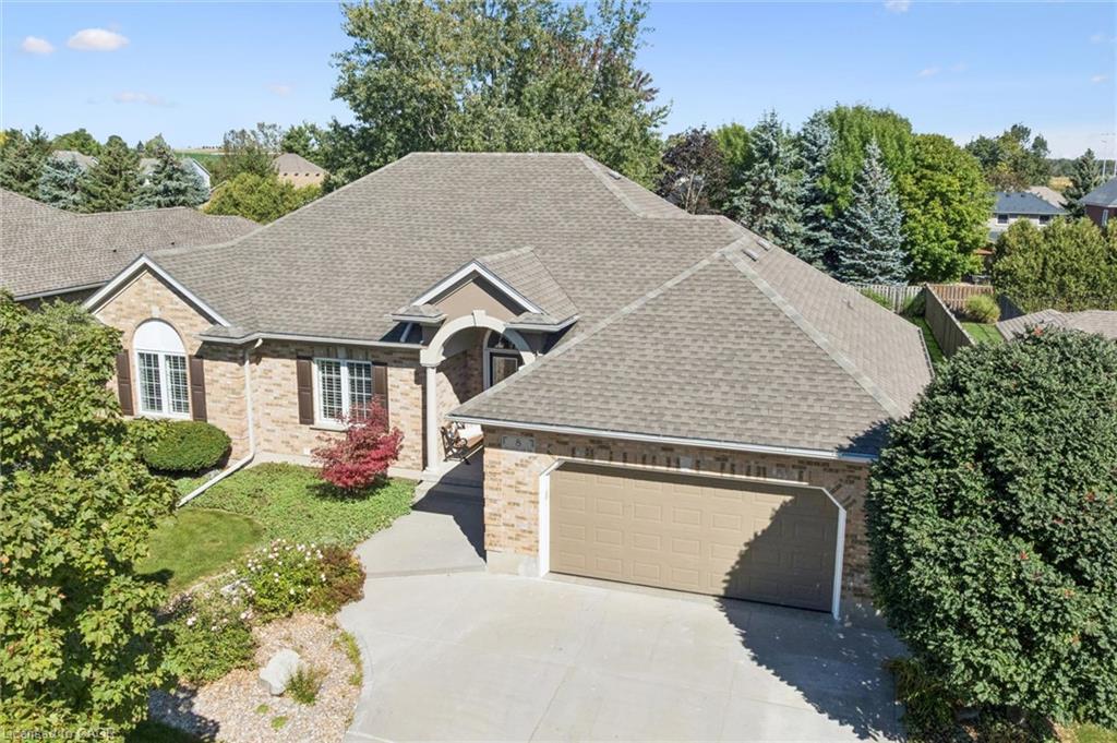 Elegant brick Colonial-style residence featuring a steeply pitched architectural roofline with multiple peaks and dormers
