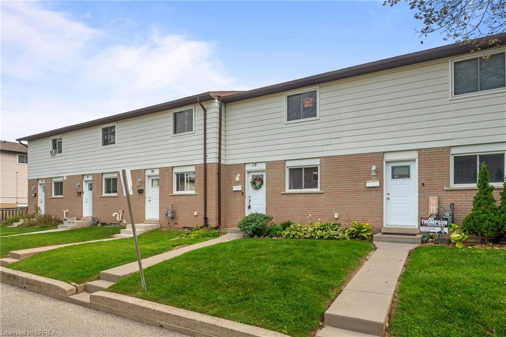 Brick and siding exterior with individual front walkways, green lawns, and established landscaping