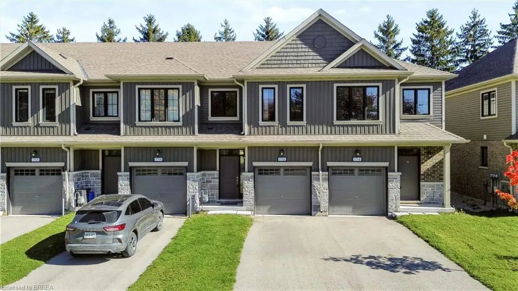 Multi-unit townhome exterior featuring vertical siding, stone veneer accents, shake-style gable detailing, and private single-car garages
