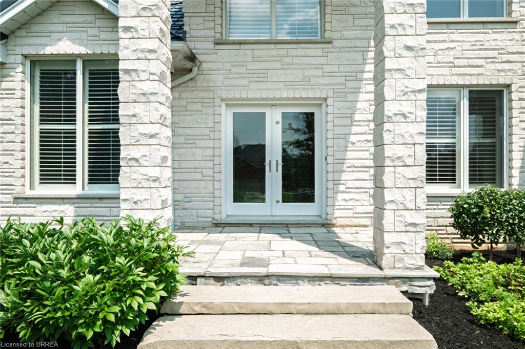 Stone veneer exterior featuring a double-door entry with glass panels