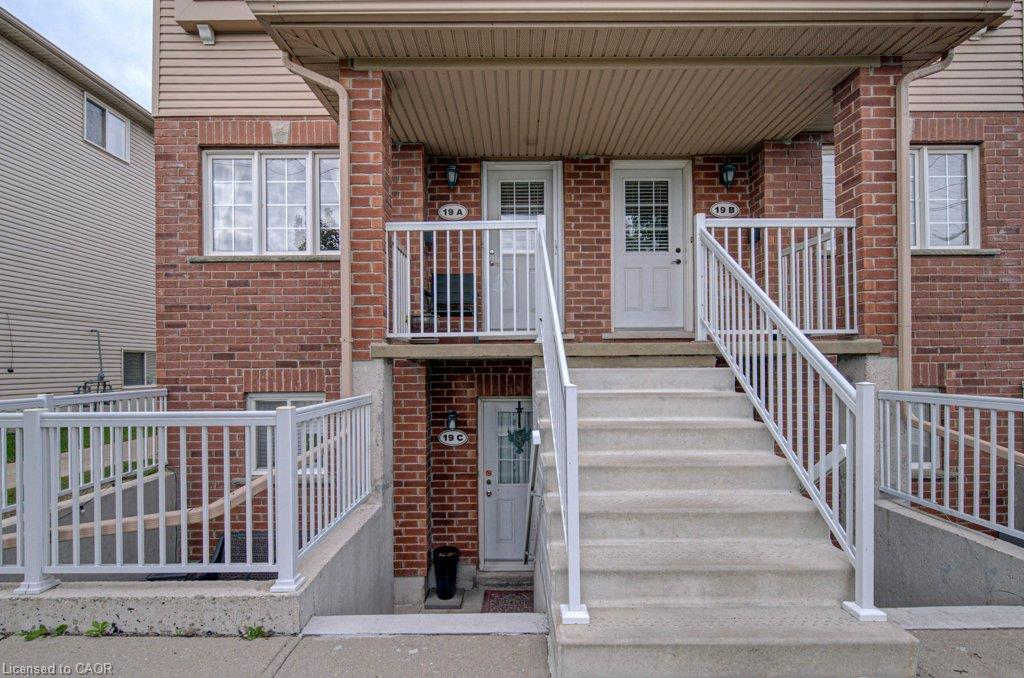 Brick facade, concrete stairs, white railings, covered entry, multiple entrances