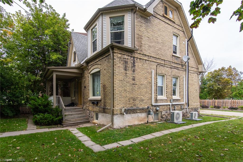 Brick and siding exterior with a covered porch, bay window, and gabled roofline