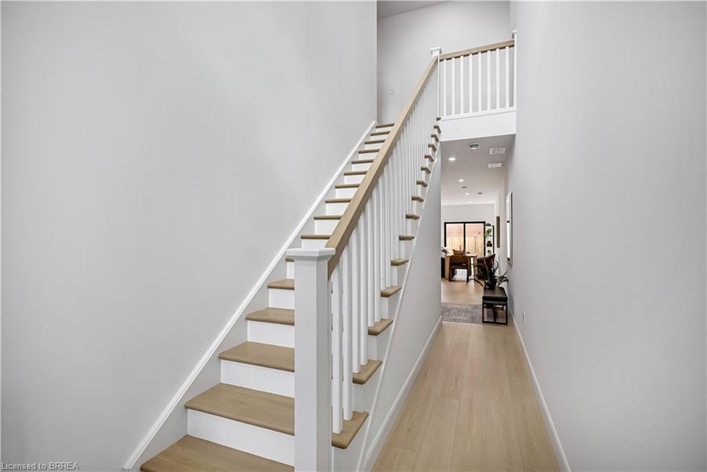 Stairway with wood finished floors and a high ceiling