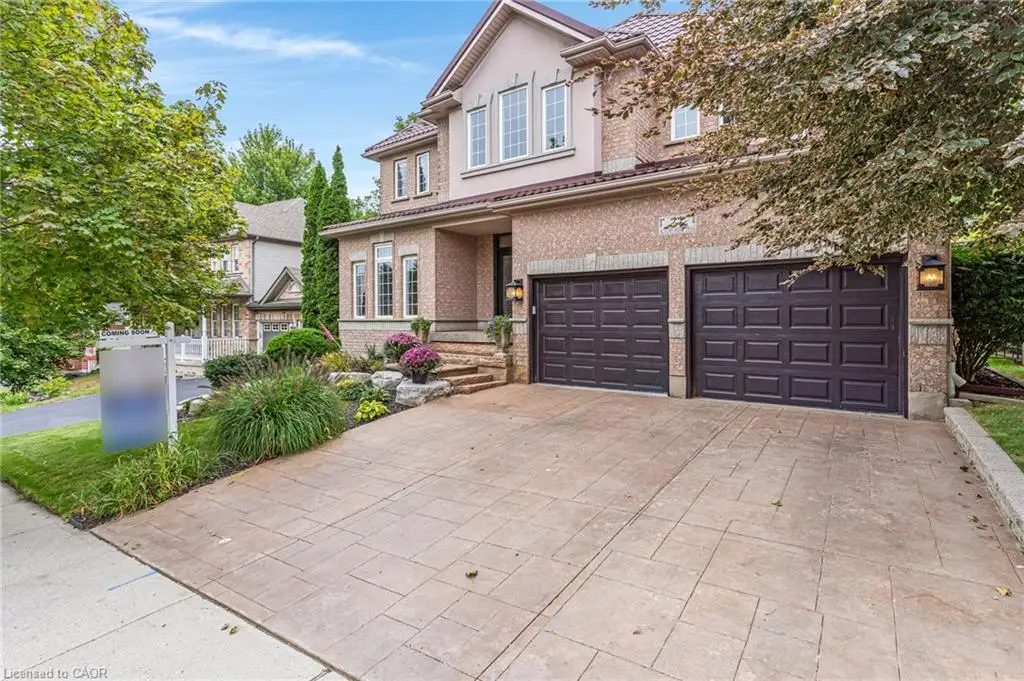 Brick exterior with stone accents and a patterned concrete driveway