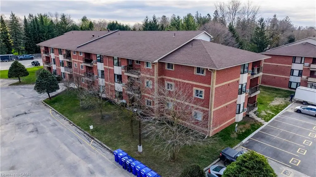 Red brick exterior with multiple balconies, a brown shingle roof, and surrounding green spaces