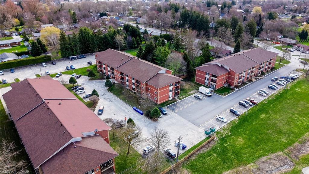 Multiple apartment buildings featuring red brick facades, private balconies, and ample surface parking