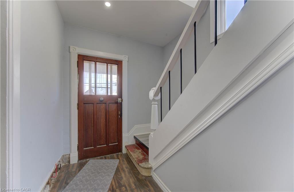 Entryway with wood finished floors, stairway, and recessed lighting