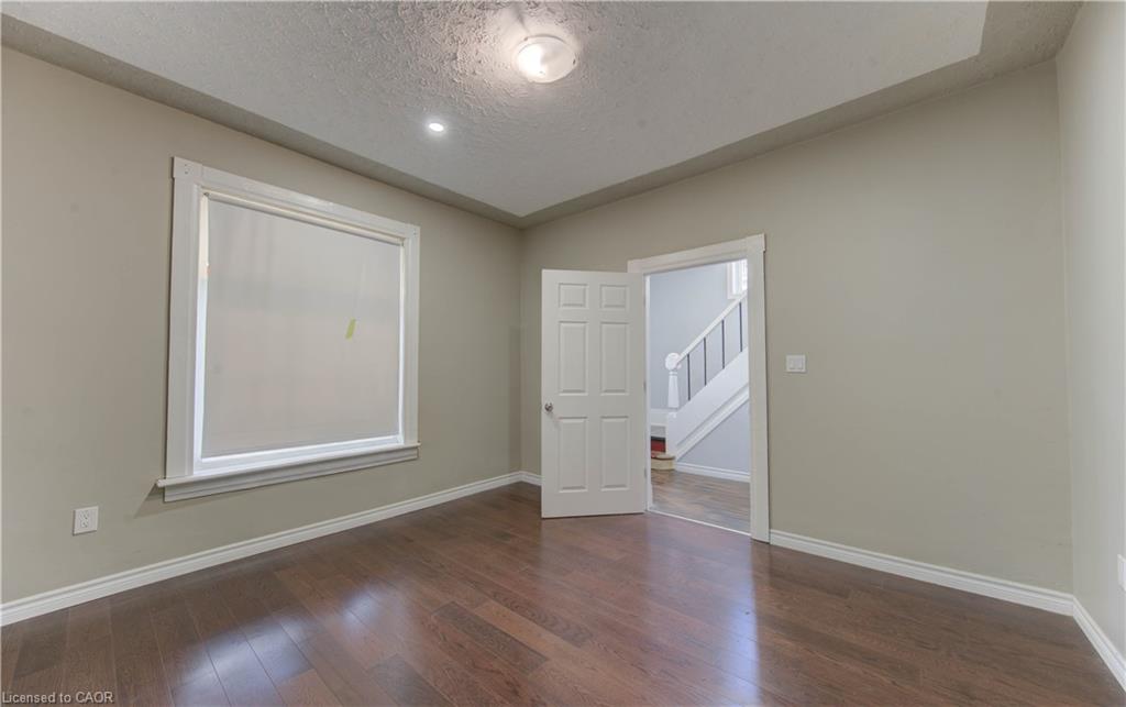 Unfurnished room featuring dark wood-style floors and a textured ceiling