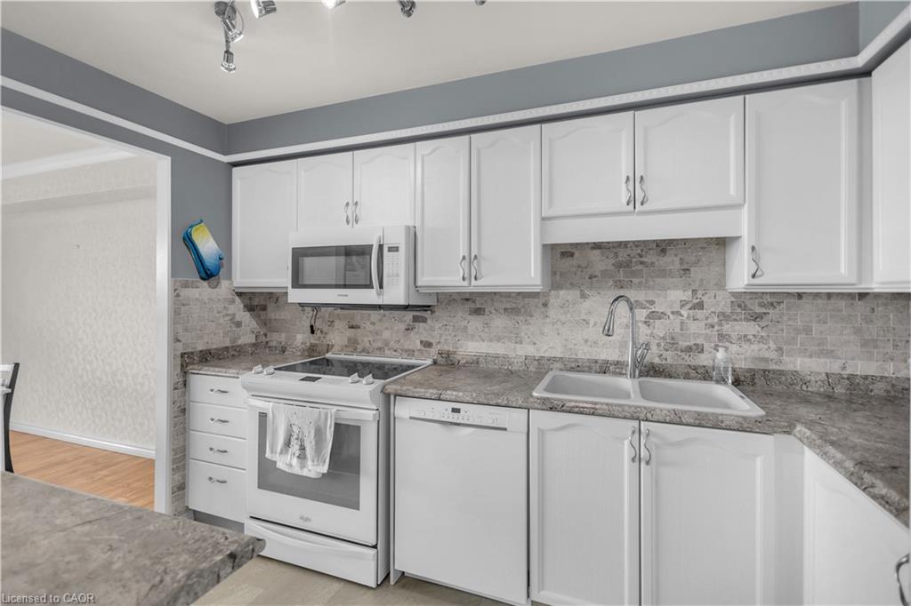 Kitchen featuring white cabinetry, a dual-basin sink with a gooseneck faucet, a white electric range, and a built-in microwave