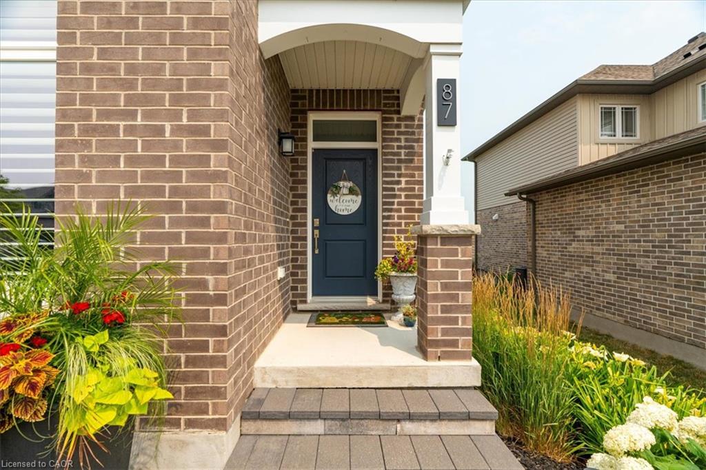 Brick facade featuring a covered porch entry with white columns