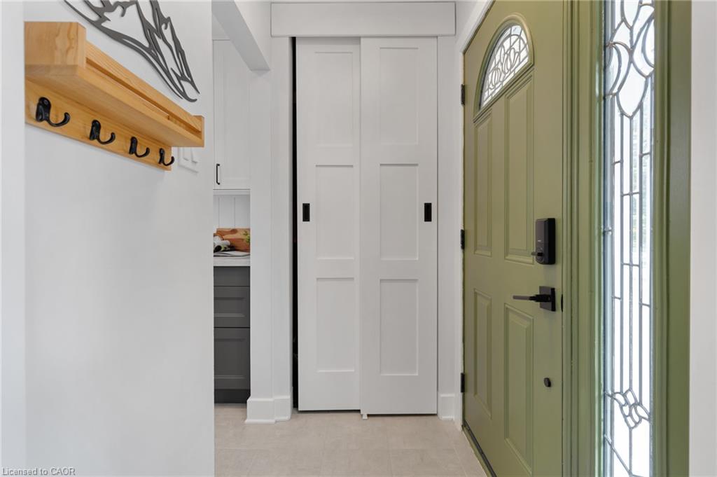 Stainless steel refrigerator, gray lower cabinetry, light wood-finish flooring, recessed lighting, and white baseboards