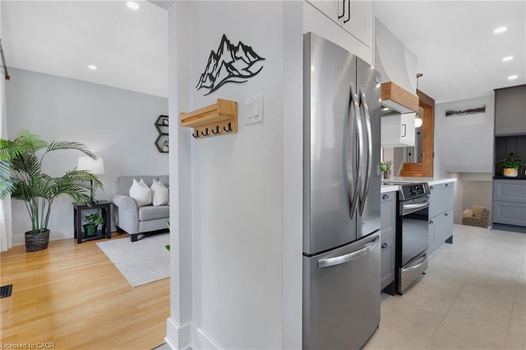 Hardwood flooring, recessed lighting, contemporary wall shelving, chandelier lighting, and a staircase with wood treads