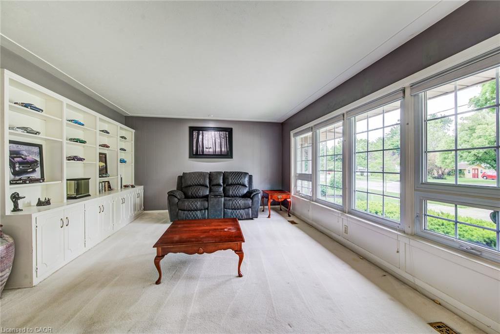 Wall-to-wall built-in shelving with lower cabinetry, light-toned carpeting, and a wall of gridded windows
