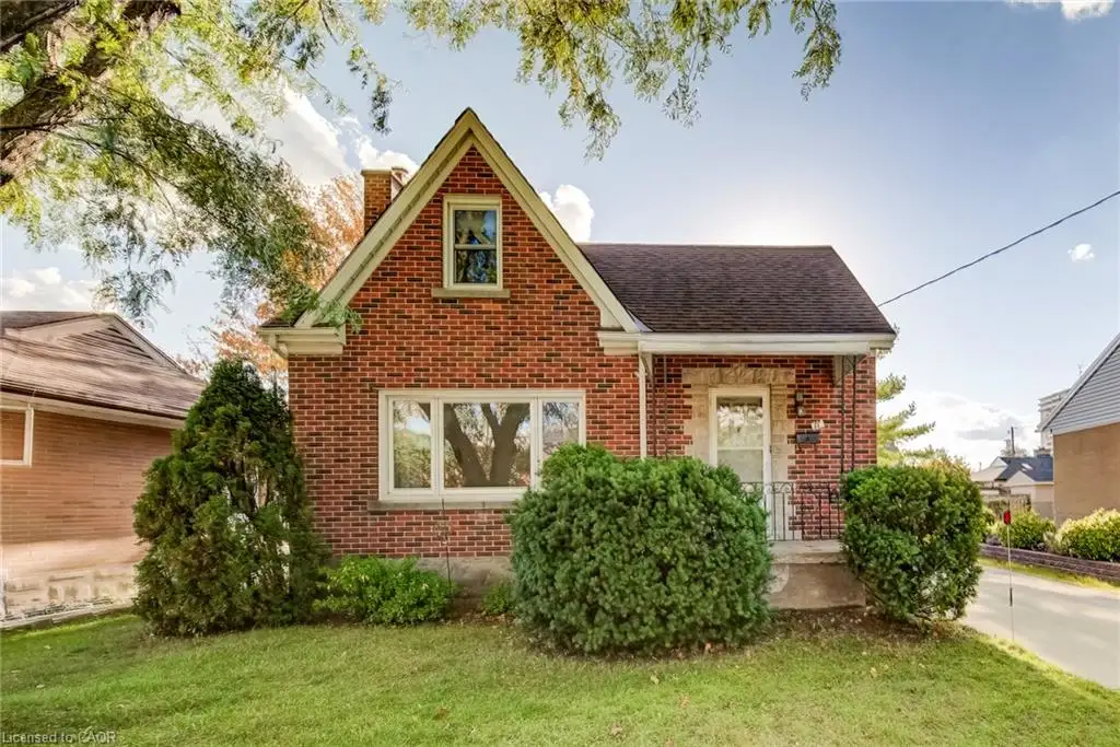 Red brick exterior with white trim, featuring a gabled roofline and covered front porch