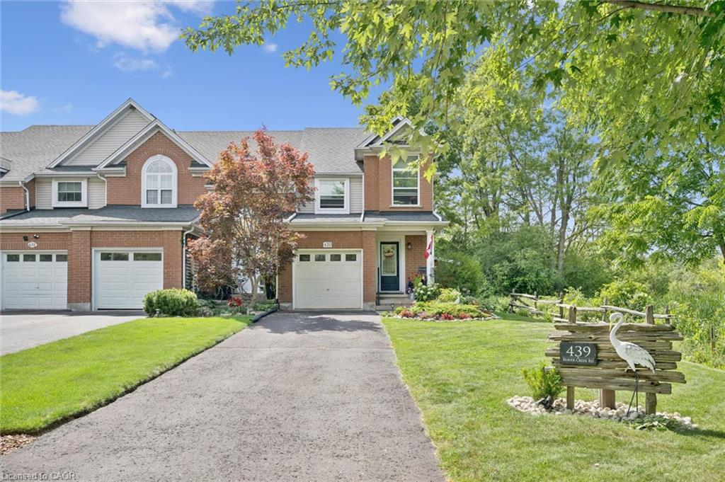 Brick exterior with a peaked roofline, an arched window, and an attached garage