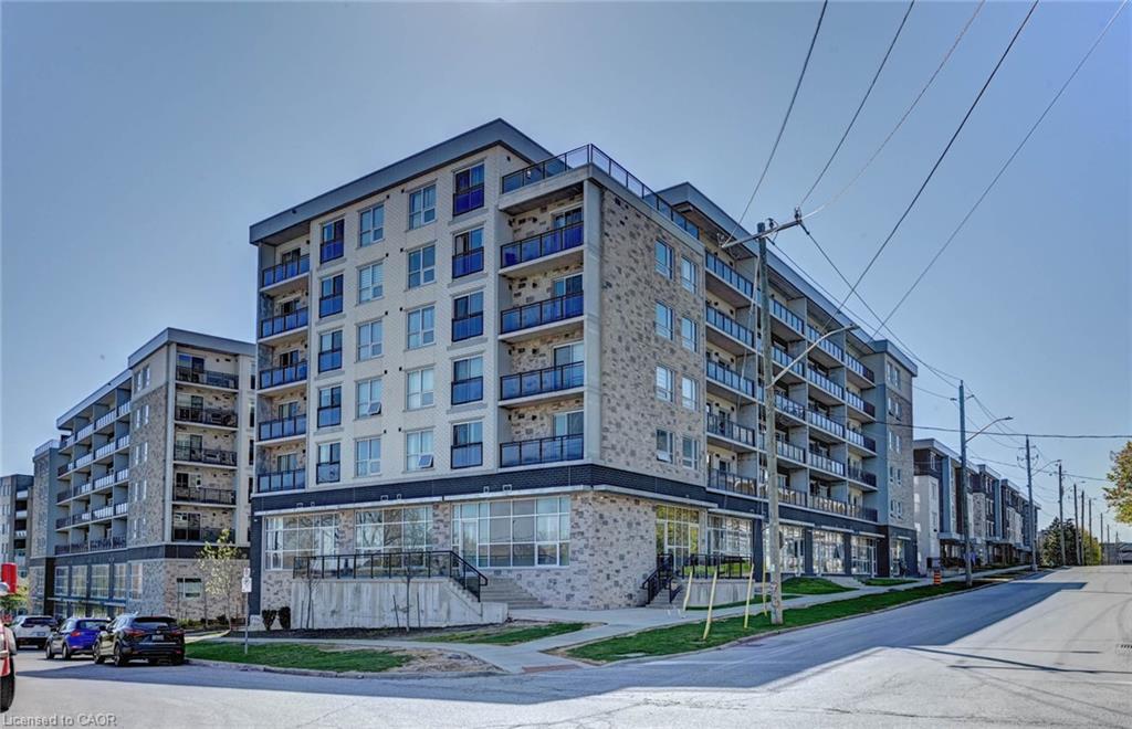 Contemporary multi-story building featuring stone and paneling facade, multiple balconies with glass railings, and a ground-floor retail space with large windows