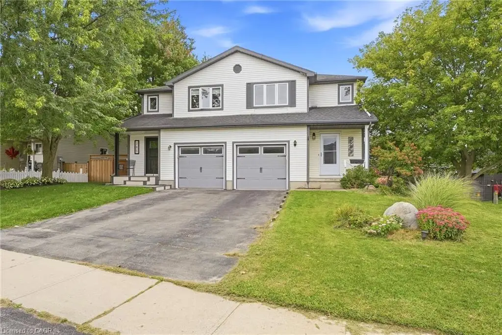Two-story residence with white siding, dark trim, and gray garage doors