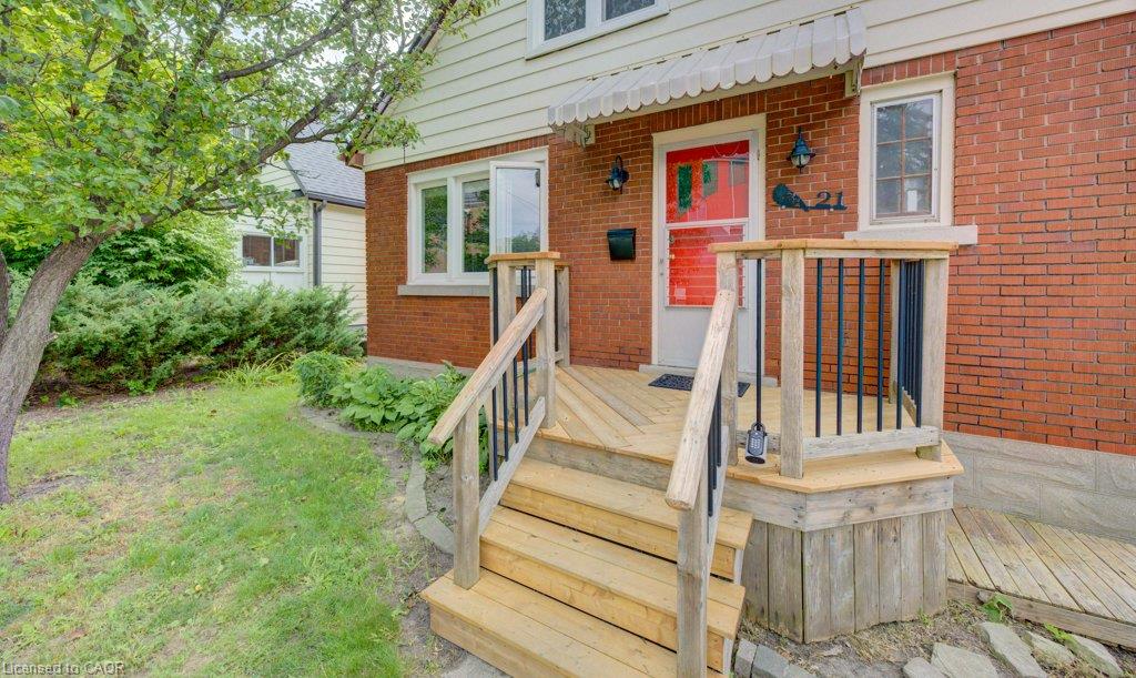 Brick exterior with white siding, wooden front porch, red entry door, and decorative awning