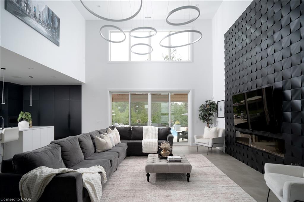 Double-height living space featuring a textured accent wall with an integrated linear fireplace