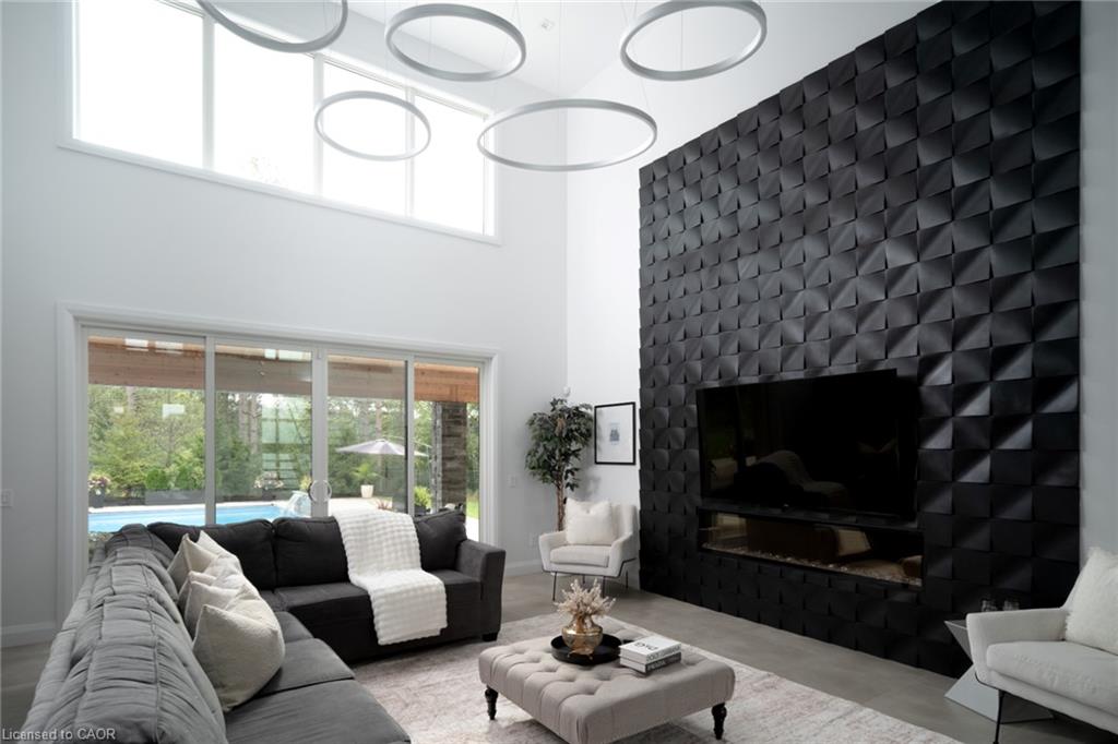 Two-story ceiling with transom windows, a textured accent wall with an integrated fireplace, and a full wall of sliding glass doors