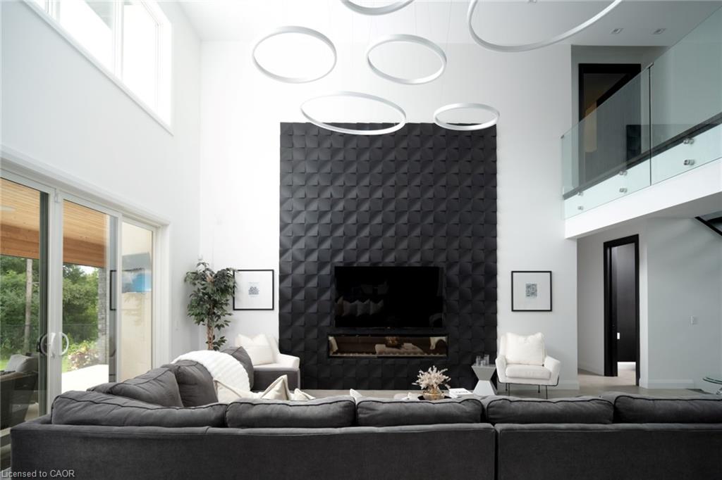 Two-story living area with a textured accent wall, integrated fireplace, and a wall-mounted television
