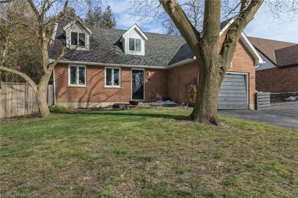View of front of home featuring brick siding, an attached garage, driveway, and a shingled roof