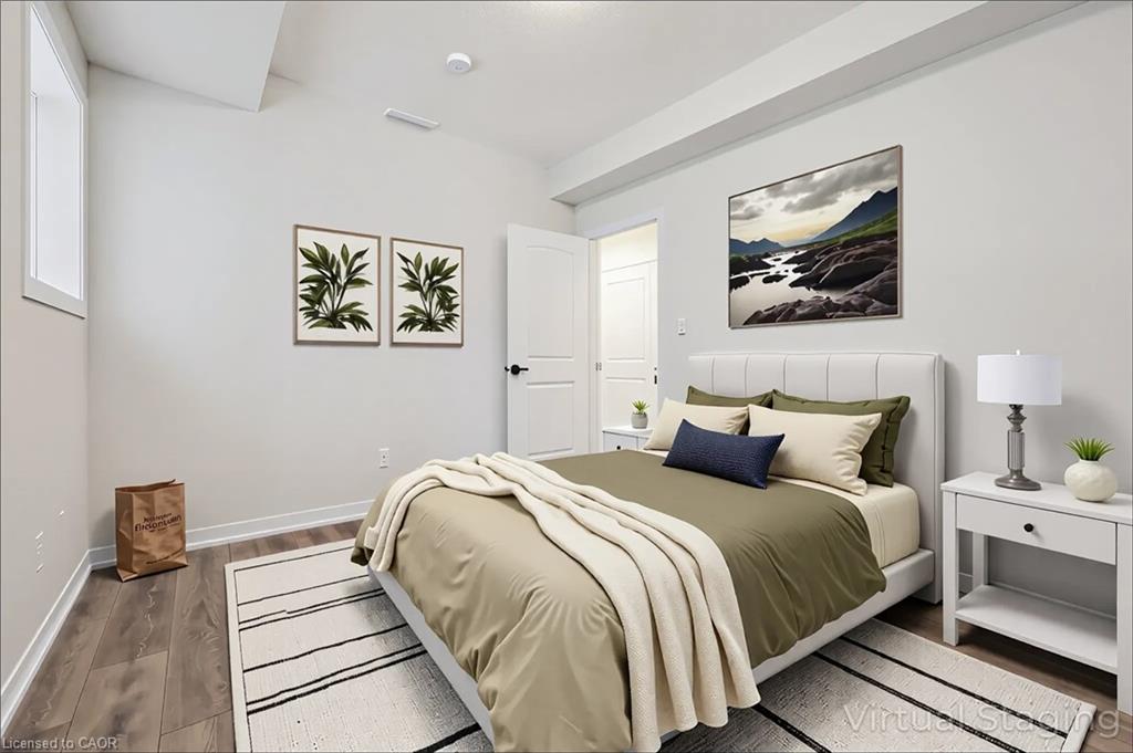 Wood-finish flooring, white walls, and a white interior door with black hardware
