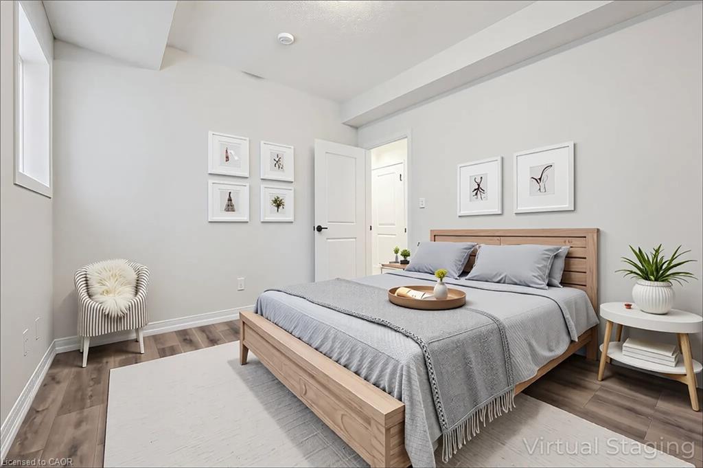 Recessed lighting, wood-finish flooring, and a white interior door with matte black hardware