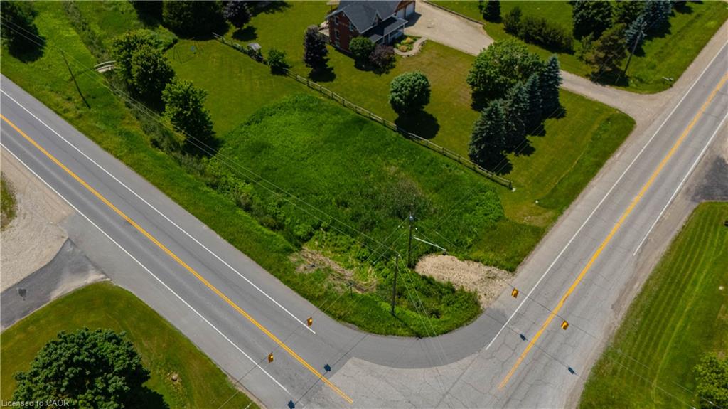 Expansive corner lot featuring green space, mature trees, and direct road access