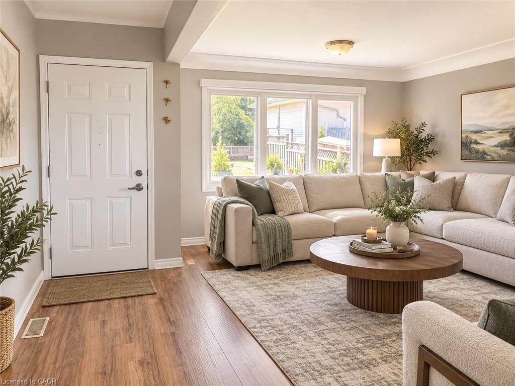 Wood-finish flooring, crown molding, large window, and ceiling-mounted light fixture