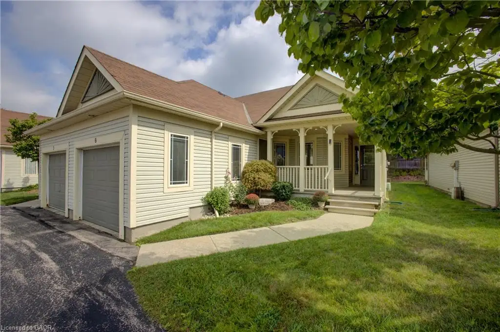 Siding exterior with a covered porch, established lawn, concrete walkway, and attached two-car garage