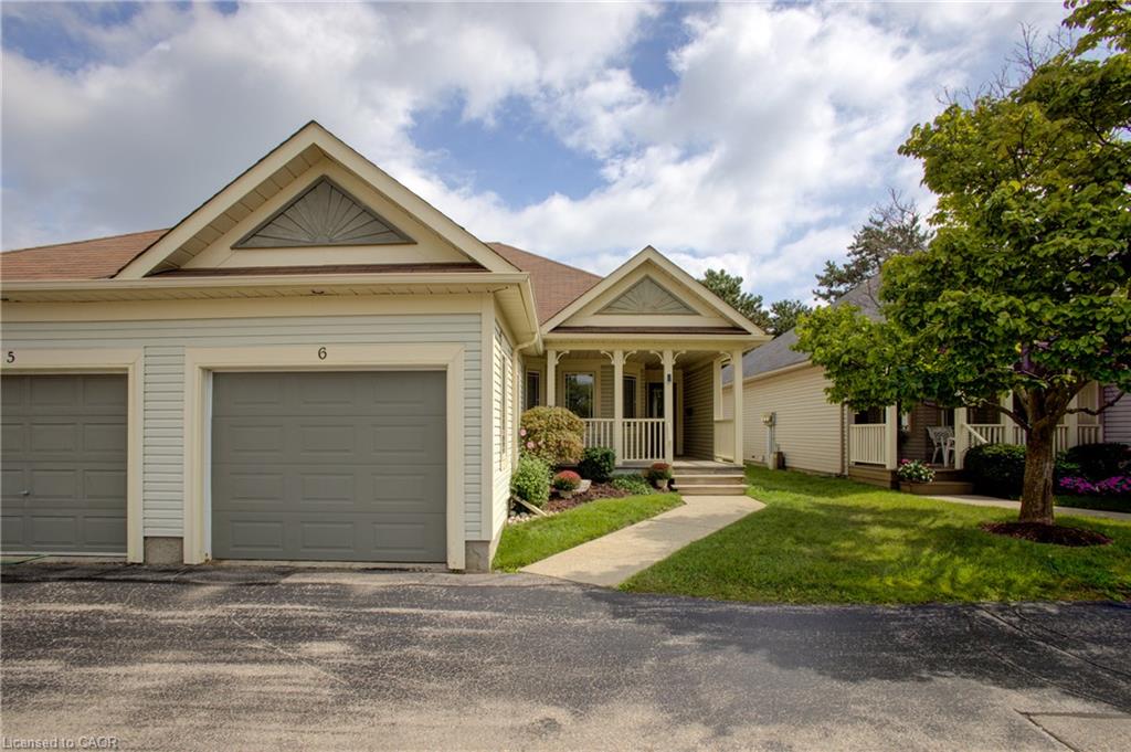 Siding exterior with an attached garage, a covered front porch, and a concrete walkway