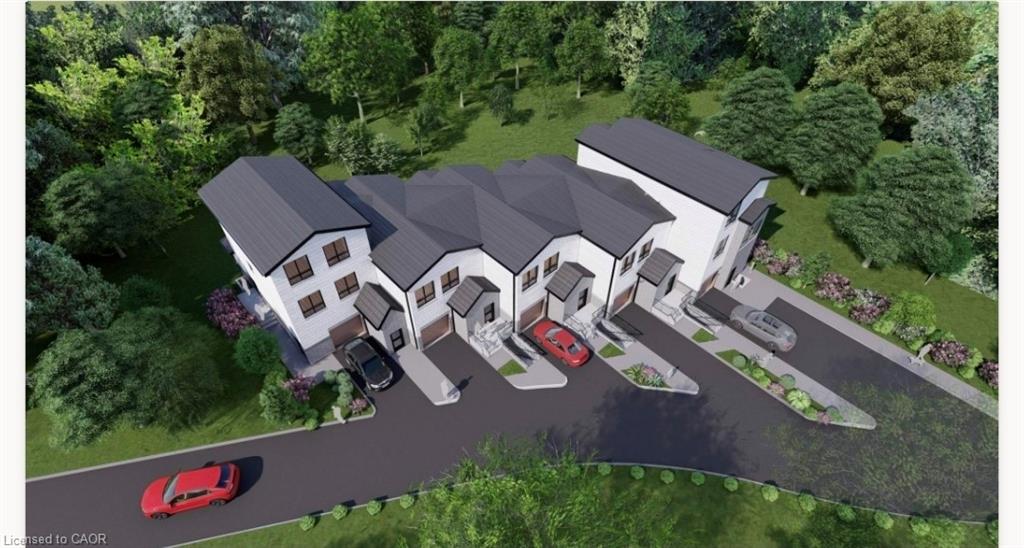 Modern townhouse development featuring individual garages, private driveways, dark grey roofs, white siding, and mature surrounding trees