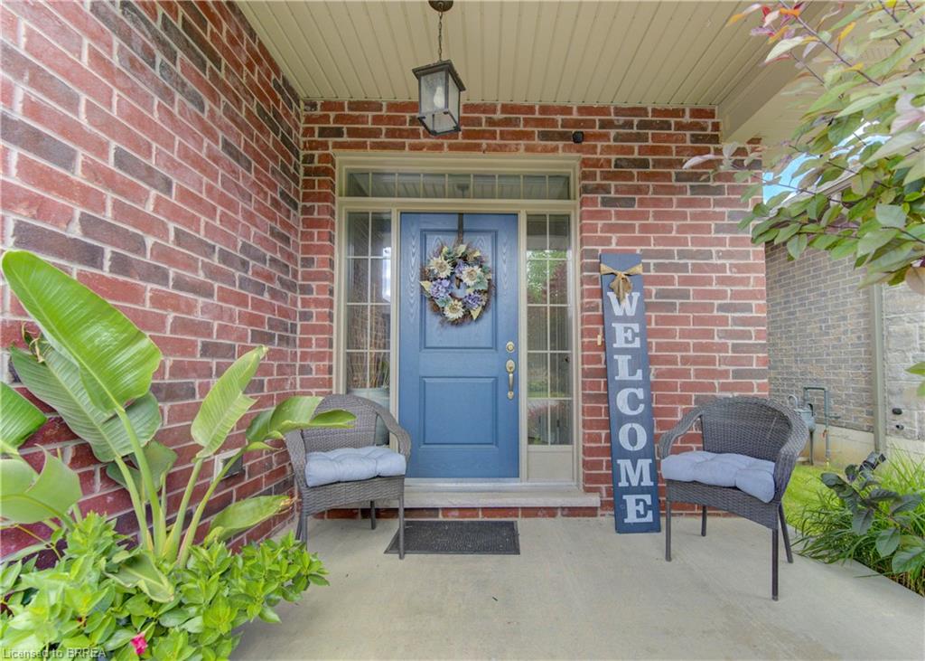 Brick facade with a covered porch featuring a blue entry door, transom, and sidelights