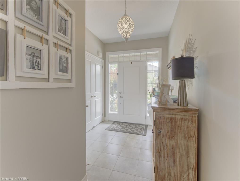Entryway featuring tile flooring, a decorative pendant light fixture, and a white paneled entry door with sidelights