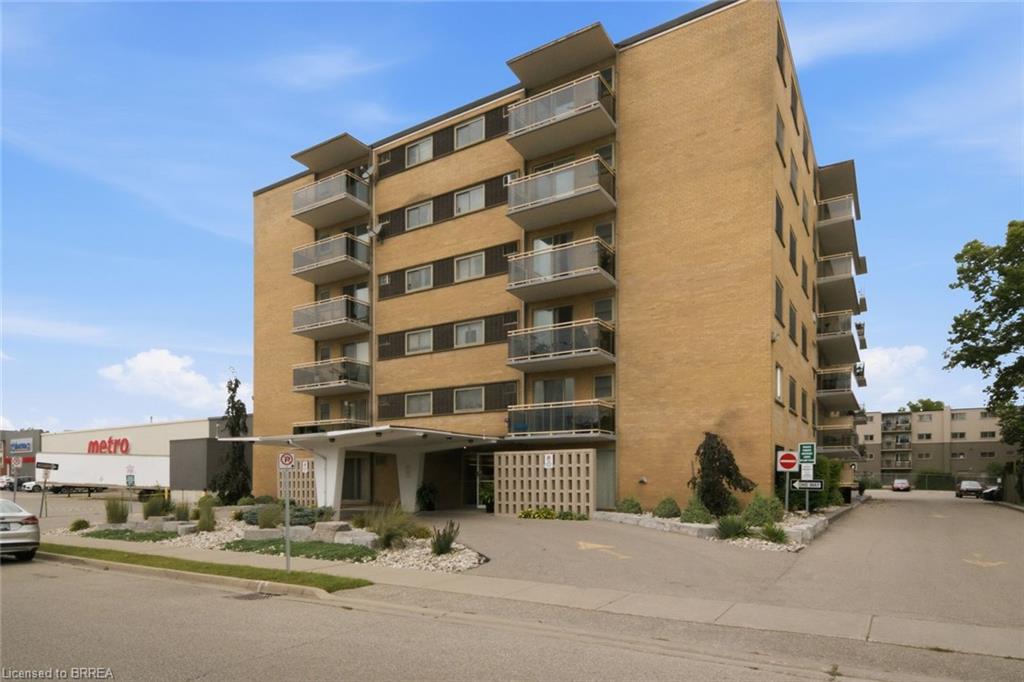 Mid-rise brick building featuring multiple private balconies with glass railings