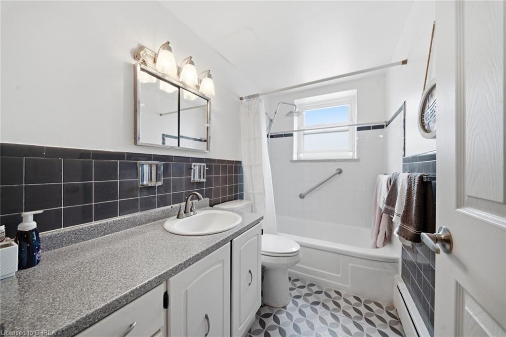 Bathroom featuring a white vanity with a gray speckled countertop, white sink, and chrome faucet