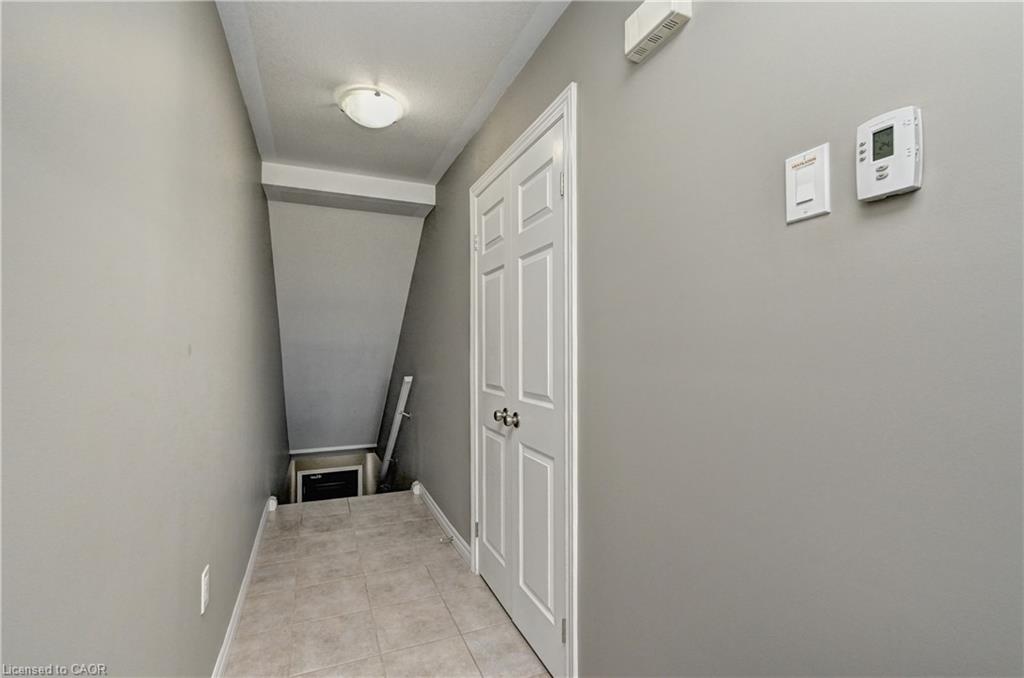 Recessed ceiling light fixture, neutral wall paint, white interior door with dark hardware, and tile flooring