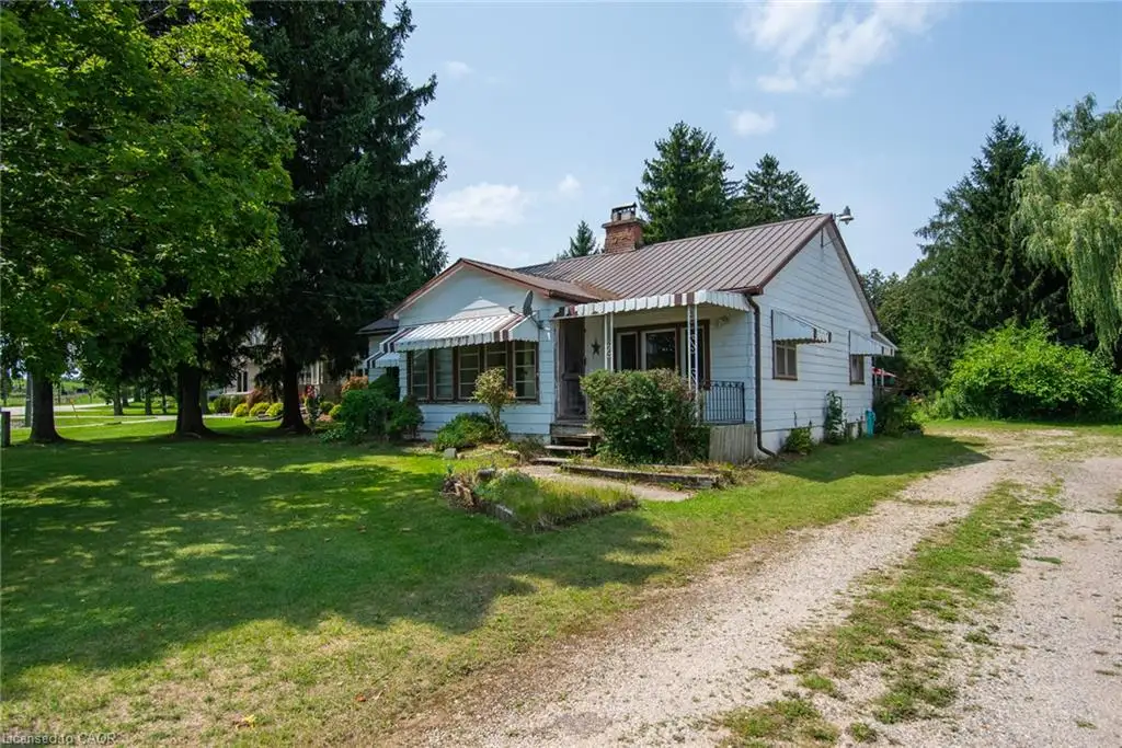 Charming cottage-style home set on expansive grounds with mature landscaping and towering evergreens