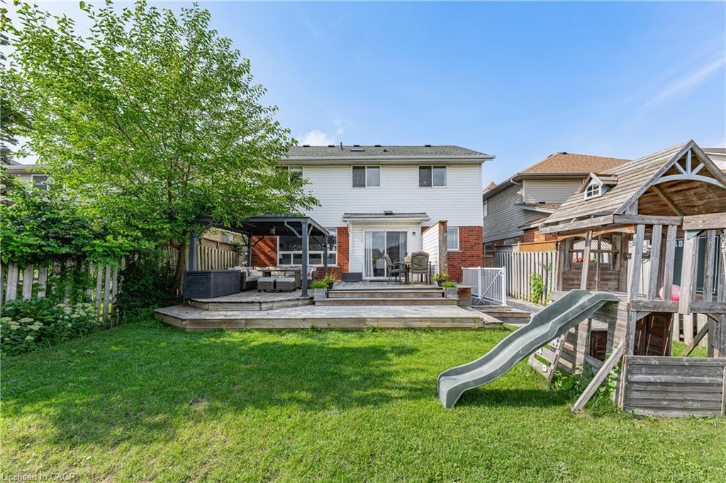 Expansive backyard featuring a multi-level wood deck, a covered patio area, and a large grassy lawn