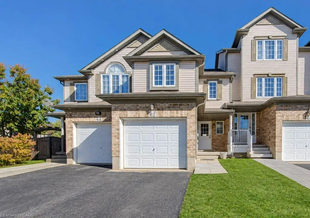 Multi-level exterior featuring light-toned vinyl siding, brick masonry, an integrated single-car garage, and multiple gabled rooflines