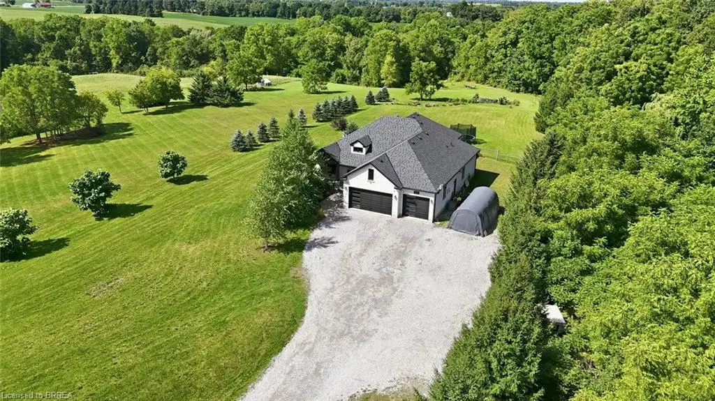 Two-story exterior with a dormer window, attached two-car garage, and gravel driveway