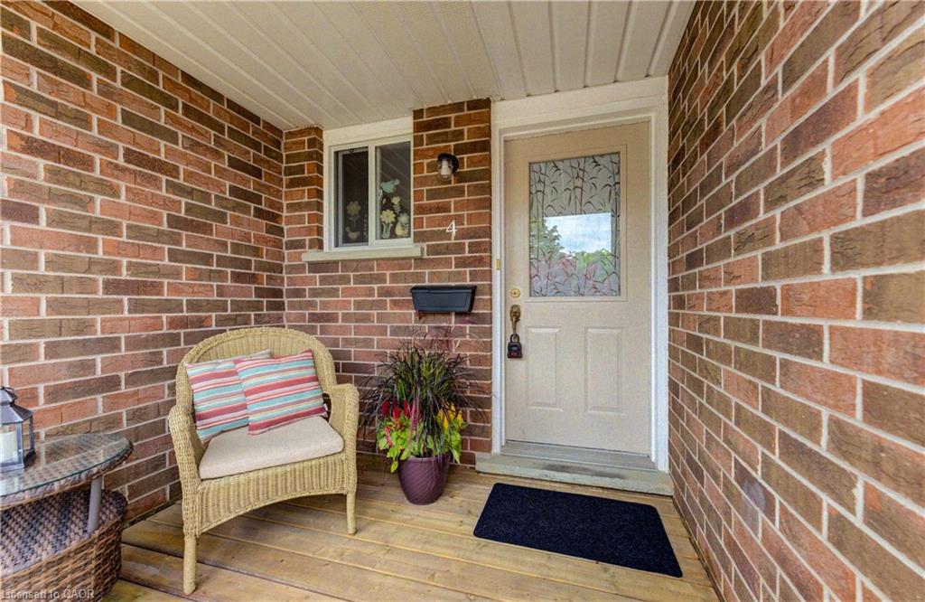 Brick facade with a covered porch featuring wood-finish decking