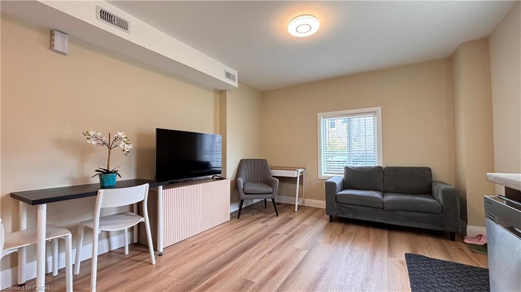 Wood-finish flooring, recessed lighting, neutral wall tones, and a window with blinds