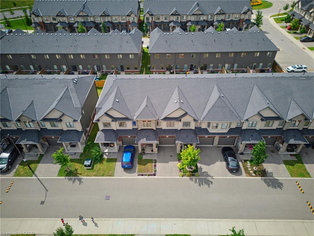 Modern townhome community featuring uniform dark gray roofs and light-toned siding
