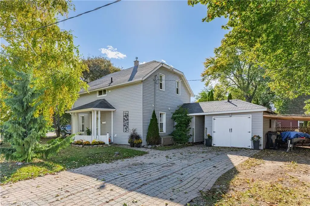 Two-story residence with light gray siding, a covered front porch, and a paved driveway