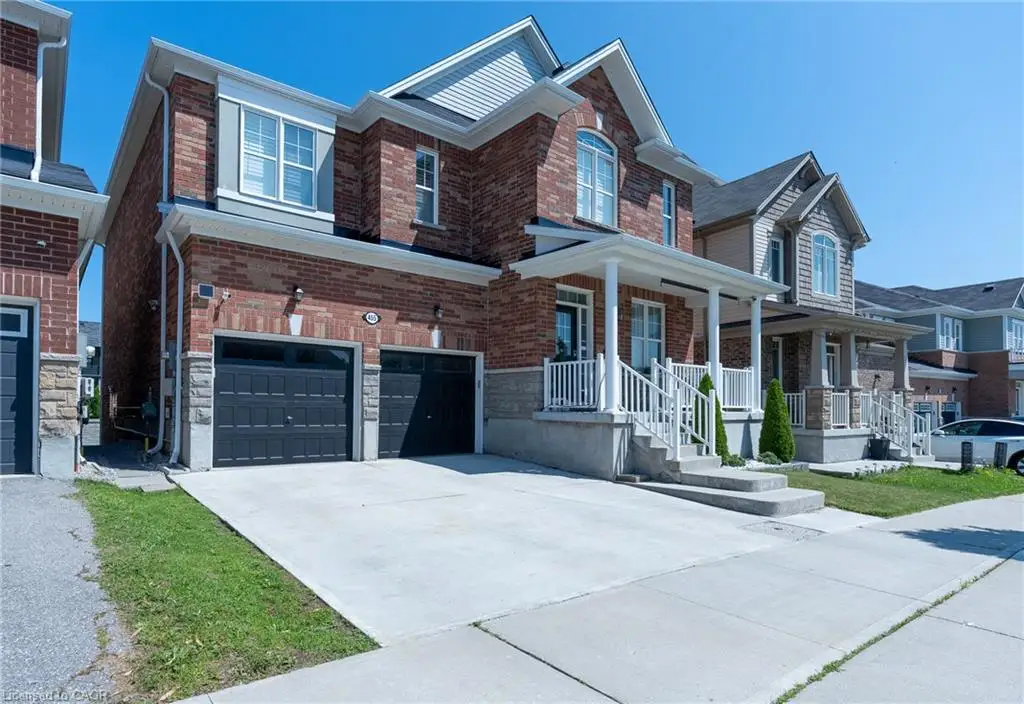 Brick exterior with stone accents, covered front porch, two-car garage, and concrete driveway