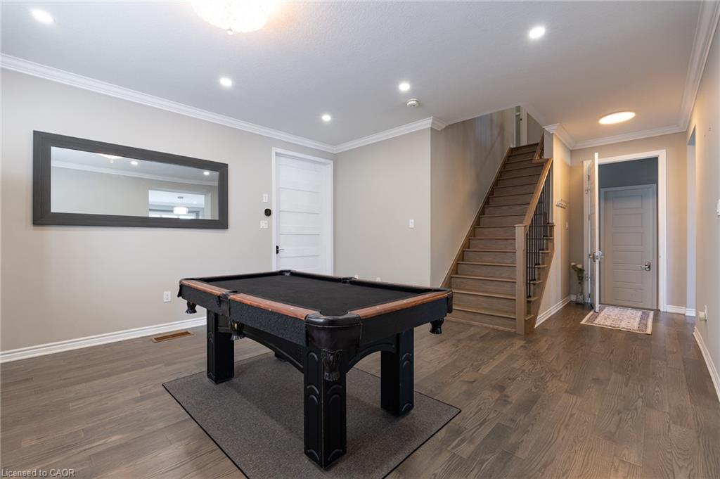Wood-finish flooring, recessed lighting, crown molding, paneled interior doors, and a wood staircase with metal balusters