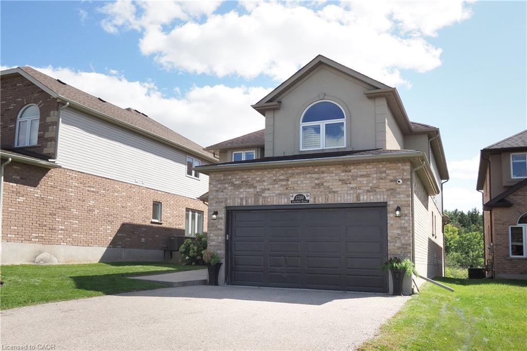 Brick and stucco exterior with an attached two-car garage, arched window, and paved driveway